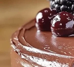 A rich, moist Chocolate Cassis Cake topped with glossy ganache and fresh blackcurrants.